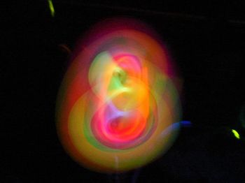 Close-up of multi colored light painting against black background