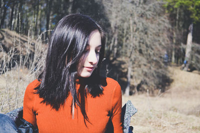 Portrait of beautiful young woman lying on land