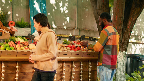 Rear view of woman holding food at market