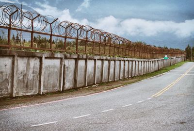 Empty road against cloudy sky