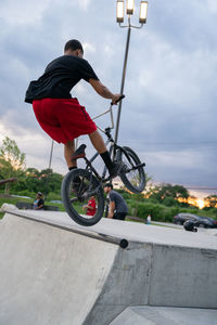 Man riding bicycle against sky