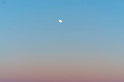 Low angle view of moon against clear blue sky