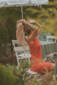 Side view of woman sitting on field