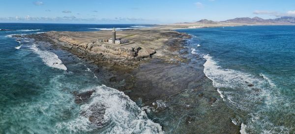 Scenic view of sea against sky with lighthouse