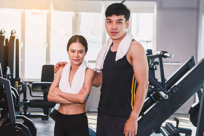 Portrait of young man and woman standing at gym