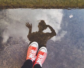 Low section of person standing in puddle