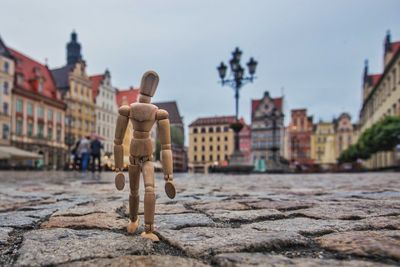 Rear view of statue in city against sky