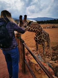 People standing at zoo against sky