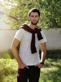 Portrait of young man standing against plants