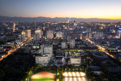 High angle view of illuminated cityscape against sky during sunset