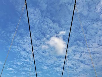 Low angle view of power lines against blue sky