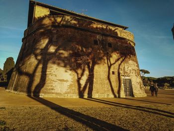 Low angle view of people walking on old building