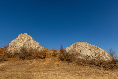 Panoramic view of arid landscape against clear blue sky