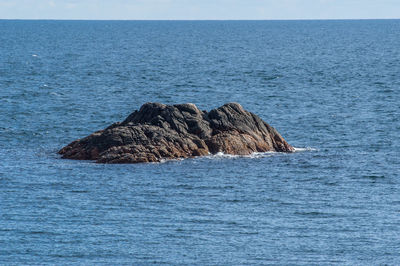 Scenic view of rocks in sea against sky