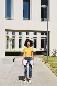 Full length portrait of man standing against building