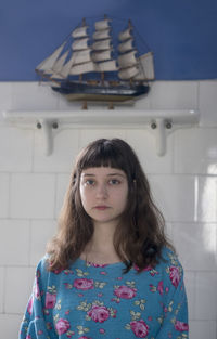 Portrait of woman standing against wall