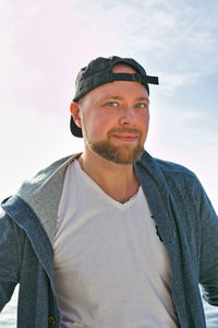 Portrait of young man standing against sky