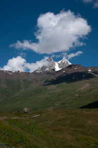 Scenic view of mountains against cloudy sky