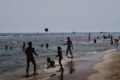People playing with ball on beach