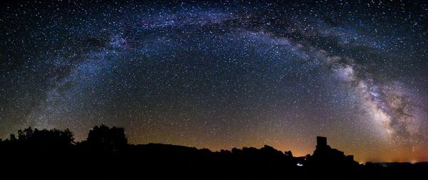 Low angle view of silhouette trees against sky at night