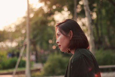 Portrait of young woman looking away outdoors