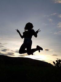 Silhouette of man jumping at sunset