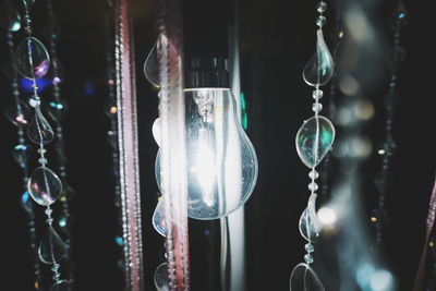 Close-up of illuminated light bulb in chandelier