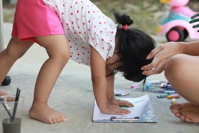 Close-up of playful girl with mother on footpath