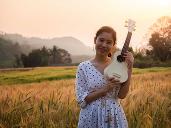 Portrait of young woman standing on field