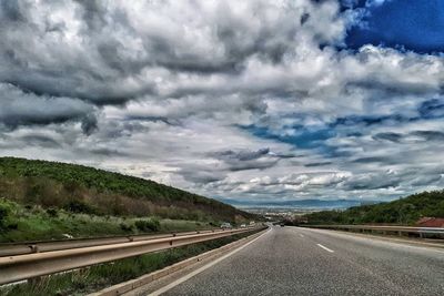 Road against storm clouds over landscape