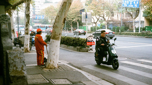 Rear view of people on street in city