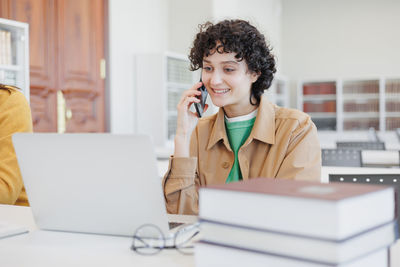 Young woman using laptop at table