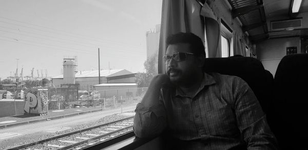 Man sitting on train at railroad station