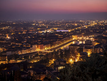 High angle view of illuminated cityscape against sky at night