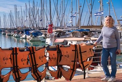 Herzliya, israel. january 8. senior lady and life jackets dry on the railings of the yacht club.