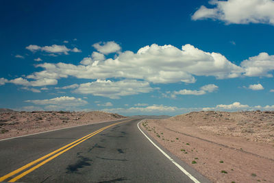 Country road against cloudy sky