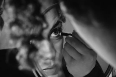 Close-up of woman applying make-up reflecting on mirror