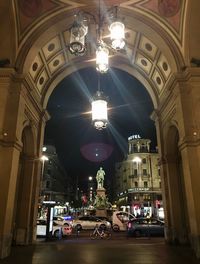 Illuminated street amidst buildings in city