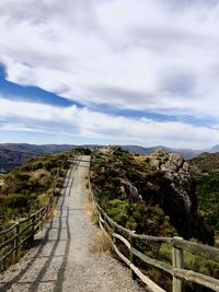 Road leading towards mountain against sky