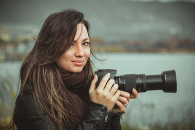 Portrait of woman photographing through camera