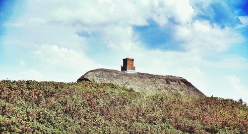 Low angle view of lighthouse against cloudy sky