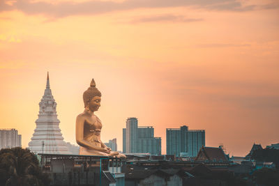 Buildings in city against sky during sunset