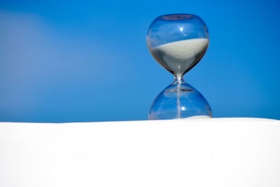 Close-up of hourglass against sky