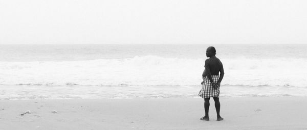 Rear view of man standing on beach