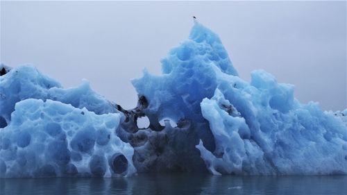 Frozen sea against sky during winter