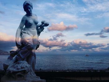 Statue against sea and sky during sunset