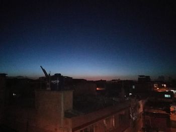 Illuminated houses against sky at night