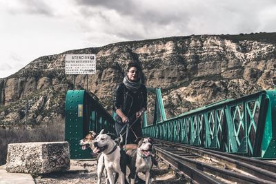 Woman with dogs standing against mountain