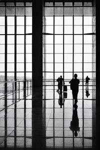 Silhouette people walking on glass window