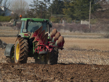 View of man driving tractor on field